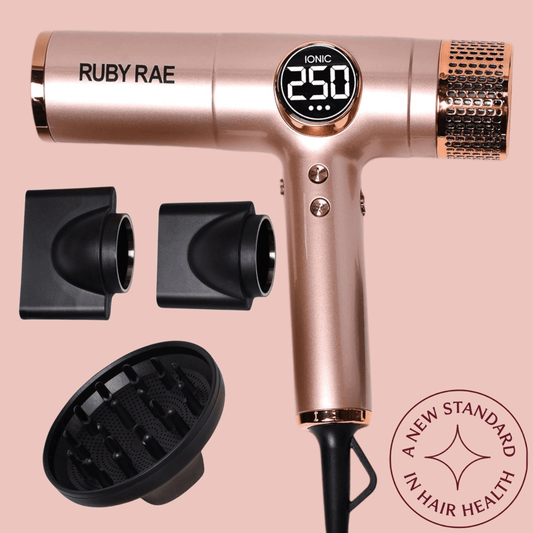 Rose gold hair dryer with attachments on a pink background, featuring the brand 'Ruby Rae'.